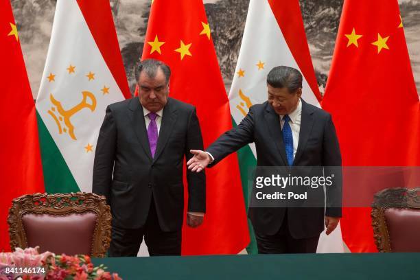 Chinese President Xi Jinping with Tajikistan's President Emomali Rahmon attend the signing ceremony during their meeting at the Great Hall of the...