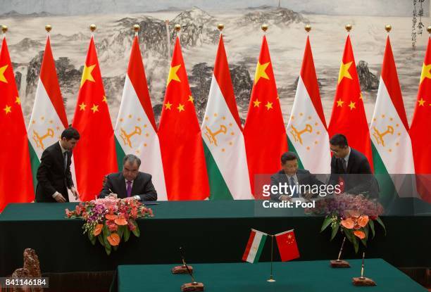 Chinese President Xi Jinping with Tajikistan's President Emomali Rahmon attend the signing ceremony during their meeting at the Great Hall of the...
