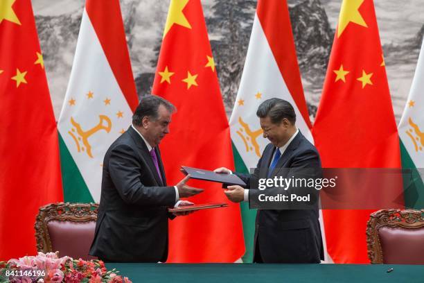 Chinese President Xi Jinping with Tajikistan's President Emomali Rahmon attend the signing ceremony during their meeting at the Great Hall of the...