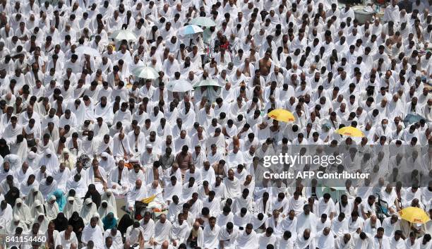 Muslim worshipers, some carrying umbrellas to protect them from the scorching sun, gather for prayer at Namirah mosque near Mount Arafat, also known...