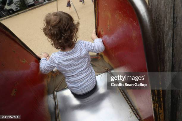 Child prepares to descend on a slide at a playground on August 31, 2017 in Berlin, Germany. With approximately three weeks to go before federal...