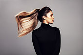 Stylish young woman with flying hair