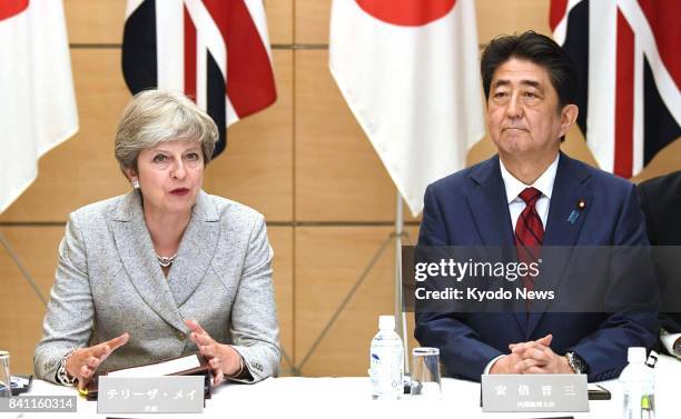 Japanese Prime Minister Shinzo Abe and his British counterpart Theresa May attend a meeting of Japan's National Security Council at the prime...