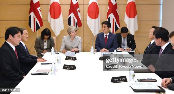 Japanese Prime Minister Shinzo Abe and his British counterpart Theresa May attend a meeting of Japan's National Security Council at the prime...