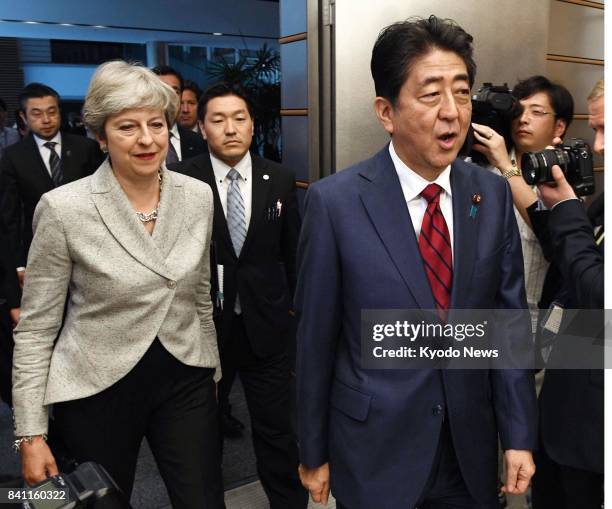 Japanese Prime Minister Shinzo Abe and his British counterpart Theresa May arrive at the prime minister's office in Tokyo on Aug. 31 to attend a...