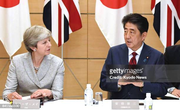 Japanese Prime Minister Shinzo Abe and his British counterpart Theresa May attend a meeting of Japan's National Security Council at the prime...