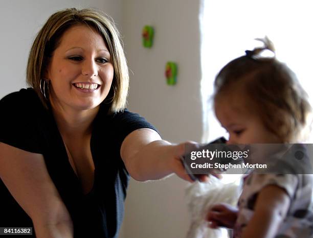 Christina Peoples tries to get 1-year-old Kasandra to talk to her father, U.S. Army Sgt. Joseph Peoples, before he departs Kuwait for home December...