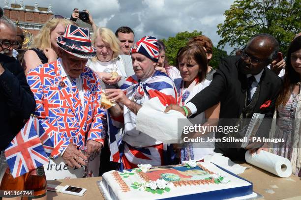 Royal fans Terry Hut and John Loughrey cut a cake to mark the twentieth anniversary of the death of Diana, Princess of Wales, outside Kensington...