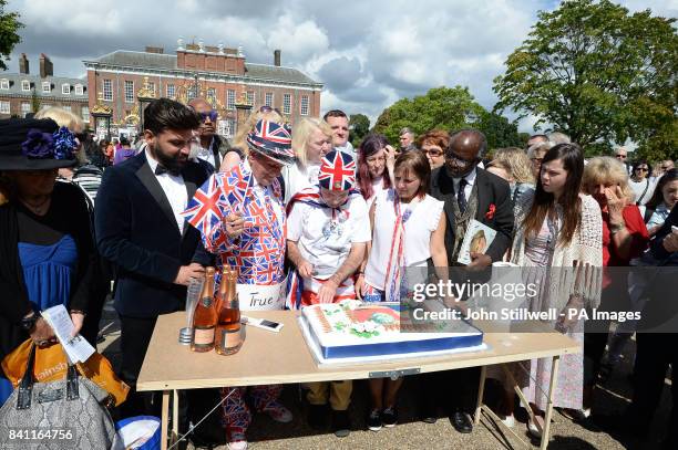 Royal fans Terry Hut and John Loughrey cut a cake to mark the twentieth anniversary of the death of Diana, Princess of Wales, outside Kensington...
