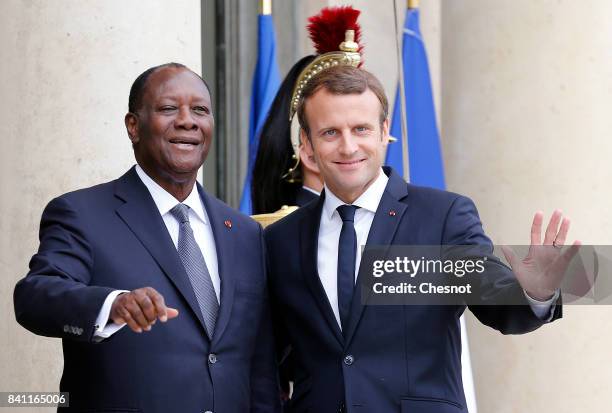 French President Emmanuel Macron welcomes Ivory Coast president Alassane Ouattara prior to a meeting at the Elysee Presidential Palace on August 31,...