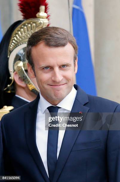 French President Emmanuel waits to welcome Ivory Coast president Alassane Ouattara prior to a meeting at the Elysee Presidential Palace on August 31,...