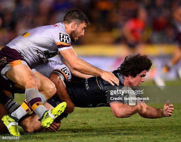 Jake Granville of the Cowboys is tackled by Ben Hunt of the Broncos during the round 26 NRL match between the North Queensland Cowboys and the...