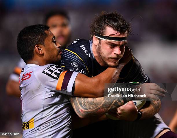 Ethan Lowe of the Cowboys is tackled by Anthony Milford of the Broncos during the round 26 NRL match between the North Queensland Cowboys and the...