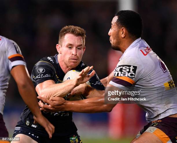 Michael Morgan of the Cowboys is tackled by Tautau Moga of the Broncos during the round 26 NRL match between the North Queensland Cowboys and the...