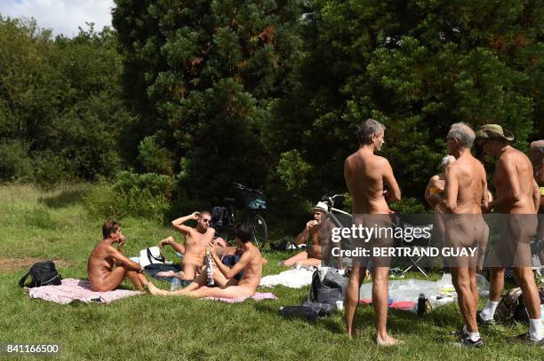 Graphic content / Naked people sit on the grass at a newly opened space for naturists at the Bois de Vincennes park in Paris on August 31, 2017. -...