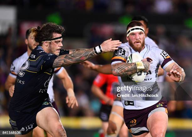 Josh McGuire of the Broncos is tackled by Ethan Lowe of the Cowboys during the round 26 NRL match between the North Queensland Cowboys and the...