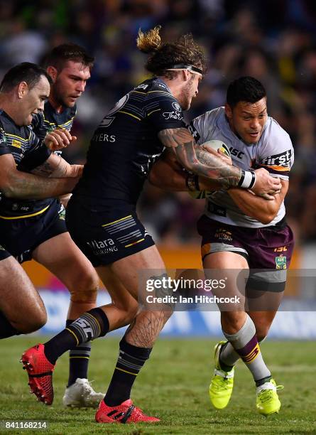 Alex Glenn of the Broncos is tackled by Ethan Lowe of the Cowboys during the round 26 NRL match between the North Queensland Cowboys and the Brisbane...