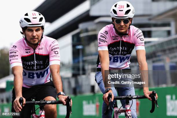 Teammates Sergio Perez of Mexico and Force India and Esteban Ocon of France and Force India cycle the track during previews for the Formula One Grand...