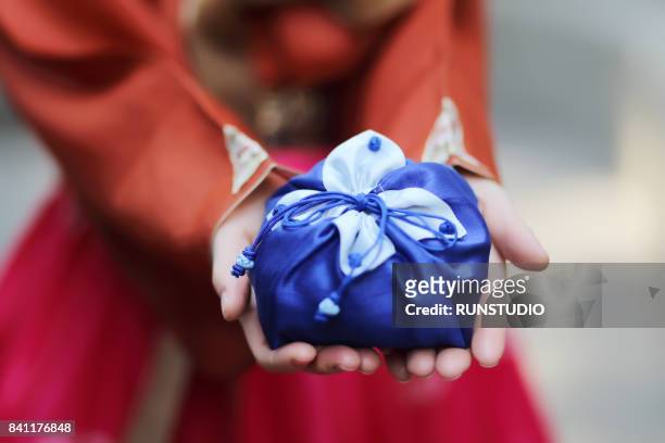 woman wearing hanbok, korean traditional dress and holding a traditional package - chuseok stock pictures, royalty-free photos & images
