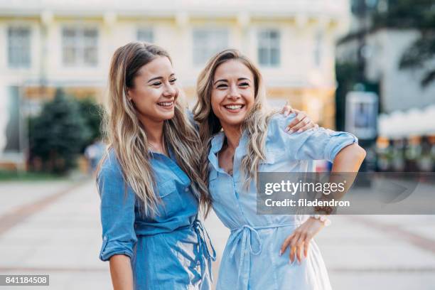 happy twins in the city - identical twin stock pictures, royalty-free photos & images