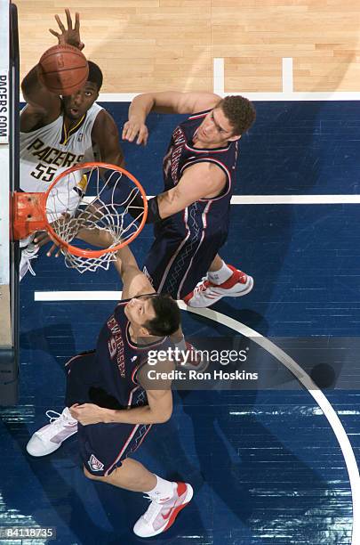 Roy Hibbert of the Indiana Pacers shoots over Brook Lopez and Yi Jianlian of the New Jersey Nets at Conseco Fieldhouse December 23, 2008 in...