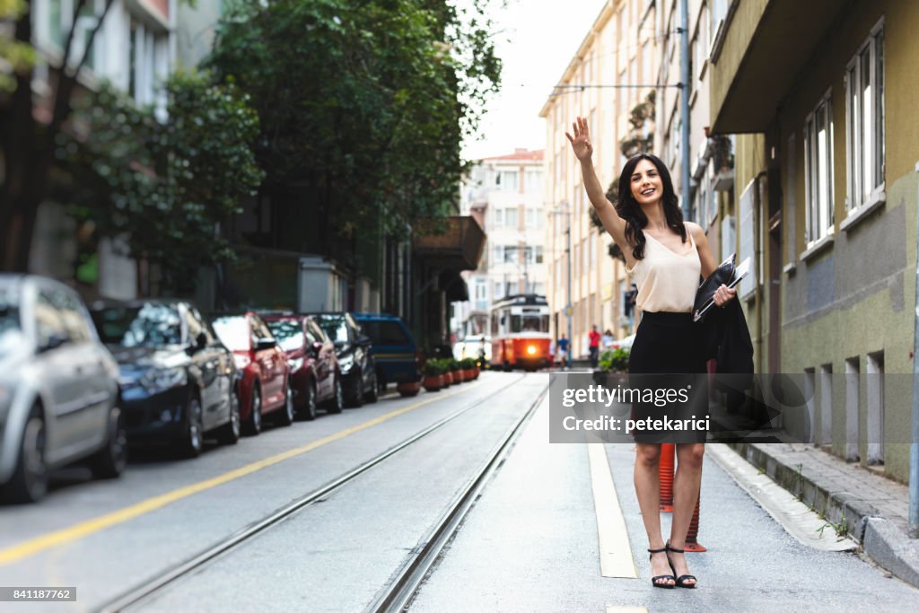Businesswoman hailing taxi in city