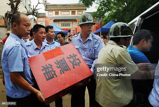 Staff members carry the ballot box to the counting site during the triennial village election at the Jiuxian Village on June 24, 2008 in Zhanjiang of...