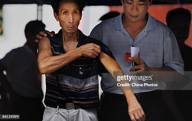 Cadre tries to calm down an angry villager who finds his ballot paper has been mistakenly drawn during the triennial village election at the Jiuxian...