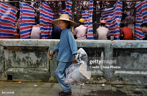 Senior citizen collects scraps outside the voting site after casting her ballot during the triennial village election at the Jiuxian Village on June...