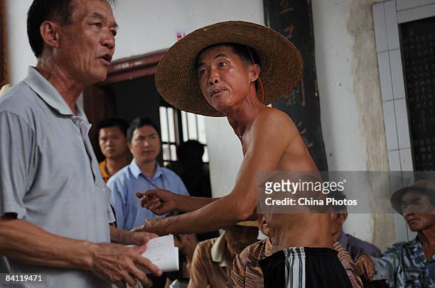 Villager argues with an election committee member during the triennial village election at the Jiuxian Village on June 21, 2008 in Zhanjiang of...