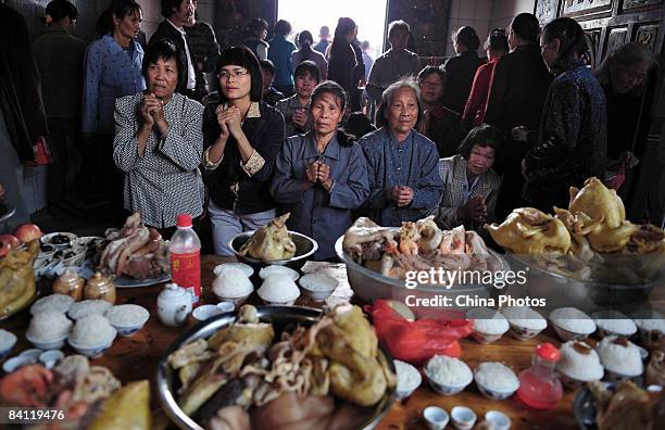 Villagers kneel infront of a buffet of food as elections take place at the Jiuxian Village on November 22, 2008 in Zhanjiang of Guangdong Province,...