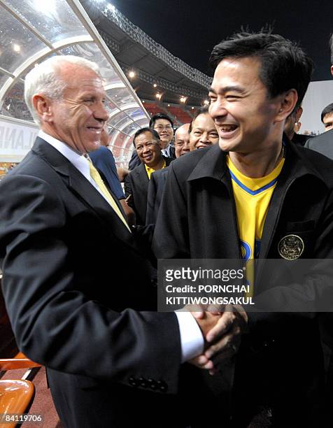 Thai Prime Minister Abhisit Vejjajiva shakes hand with Thai football coach Peter Reid during the AFF Suzuki Cup 2008 football final round first leg...