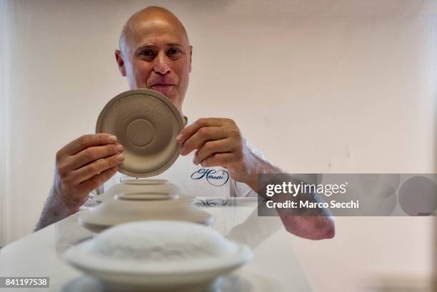 Mihaly Hoffman a staff member at Herand shows a solidified plate after having split the plaster mould on August 31, 2017 in Veszprem, Hungary. Herend...