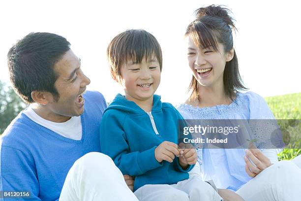 parents and boy relaxing on graas, laughing - only japanese stock pictures, royalty-free photos & images