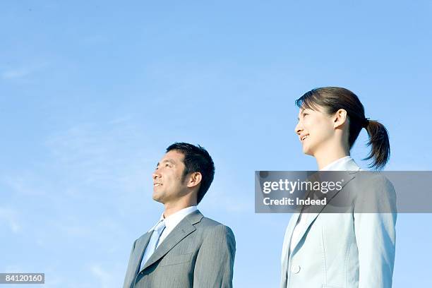 japanese businessman and woman looking away - businessman challenge stock-fotos und bilder