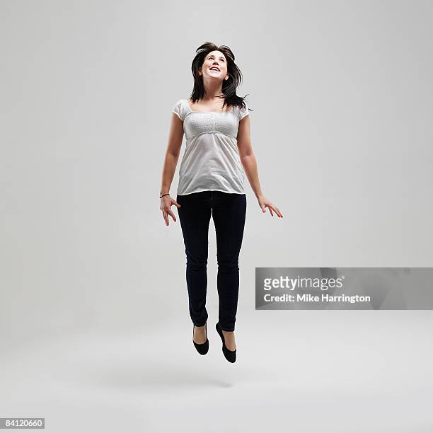 young female jumping for joy - drifting stock-fotos und bilder
