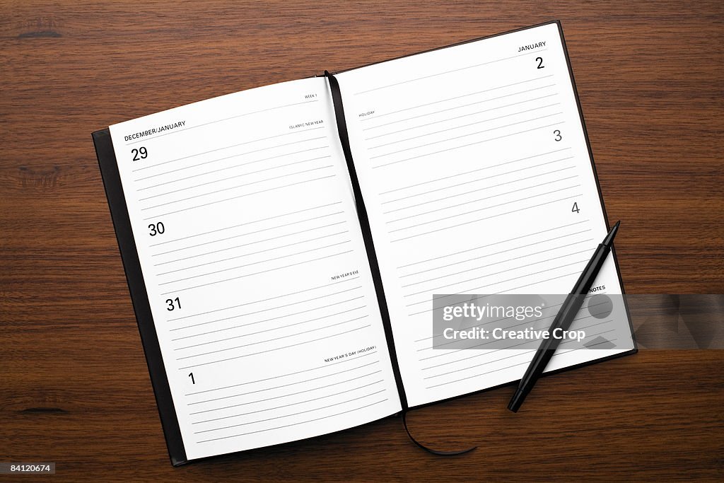 Open diary New Years Day on wood background