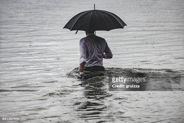 homem na chuva - wading - fotografias e filmes do acervo