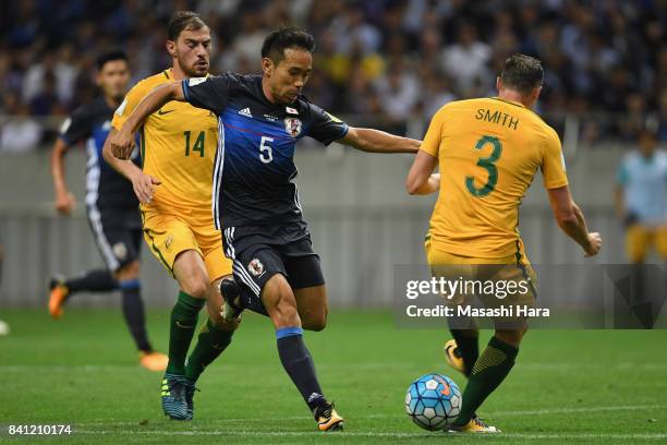 Yuto Nagatomo of Japan competes for the ball against James Troisi and Brad Smith of Australia during the FIFA World Cup Qualifier match between Japan...