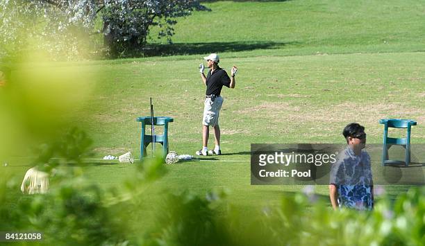 President-elect Barack Obama stretches before hitting golf balls on the driving range at Mid-Pacific Country Club December 24, 2008 in Kailua,...