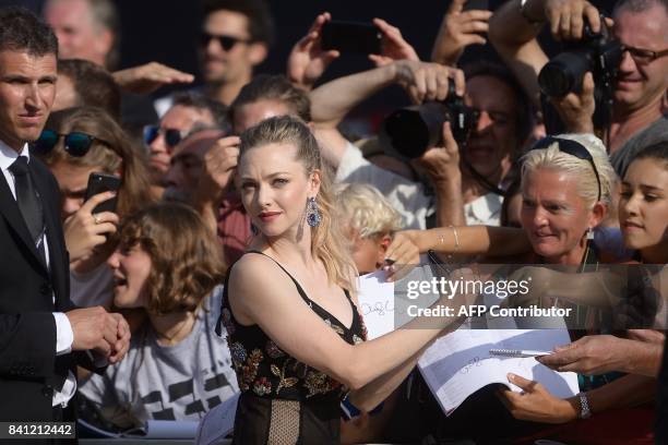 Actress Amanda Seyfried signs autographs as she arrives for the premiere of the movie "First Reformed" presented in competition at the 74th Venice...