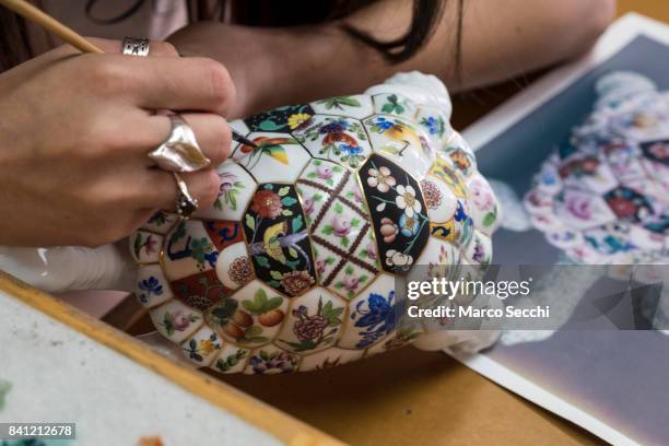 Agnes Prepost painter at Herend Porcelain hand decorates a porcelain turtle using a fine squirrel hair brush on August 31, 2017 in Veszprem, Hungary....
