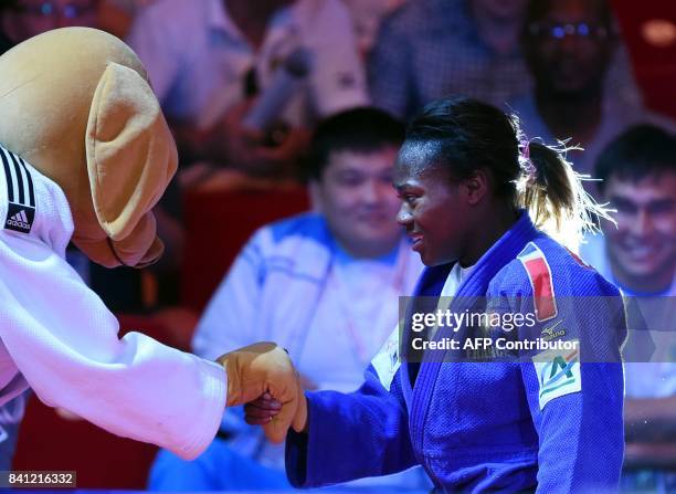 Gold medalist France's Clarisse Agbegnenou celebrates with the competition mascot mascot her victory against Slovenia's Tina Trstenjak after their...