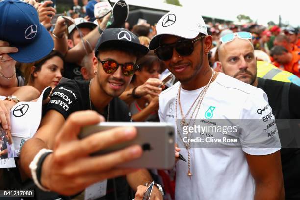 Lewis Hamilton of Great Britain and Mercedes GP poses for a selfie with a fan during previews for the Formula One Grand Prix of Italy at Autodromo di...