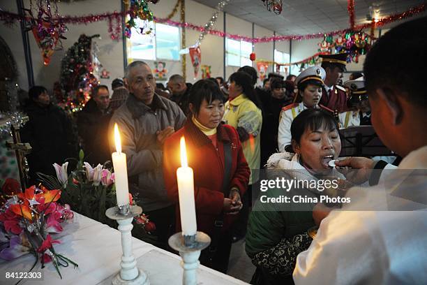 Catholics receive holy communion during a Christmas Day mass at the Church of Xiushui Township on December 25, 2008 in Anxian County of Sichuan...