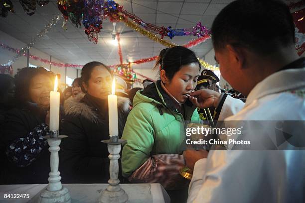 Catholics receive holy communion during a Christmas Day mass at the Church of Xiushui Township on December 25, 2008 in Anxian County of Sichuan...