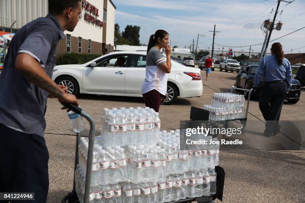 Some of the last bottles of water at the Coastal Industrial and Specialty gas welding supplies store are brought to vehicles as people try to...