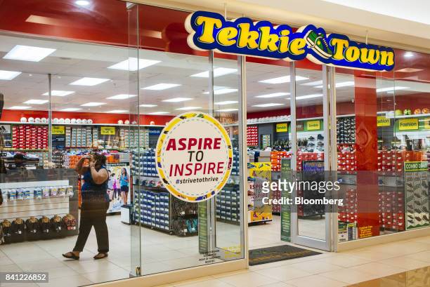 Customer uses a mobile phone while visiting a Tekkie Town shoe store, operated by Steinhoff International Holdings NV, in Pretoria, South Africa, on...