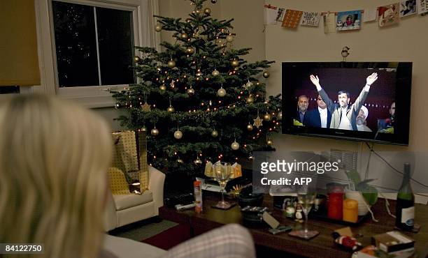 Viewer watches a transmission of Iranian President Mahmoud Ahmadinejad delivering, on Britain's Channel 4, an alternative "Christmas message" to...