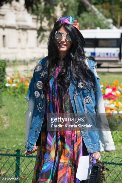 Guest wears a Chanel dress and cap, with converse trainers and a denim jacket with Chanel badges day 3 of Paris Haute Couture Fashion Week...